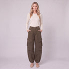 Inara baggy cargo trousers in dark olive brown, full-length view with hands in the pockets