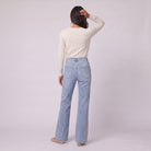 Lavinia high rise flared jeans in light wash blue denim, back view on model