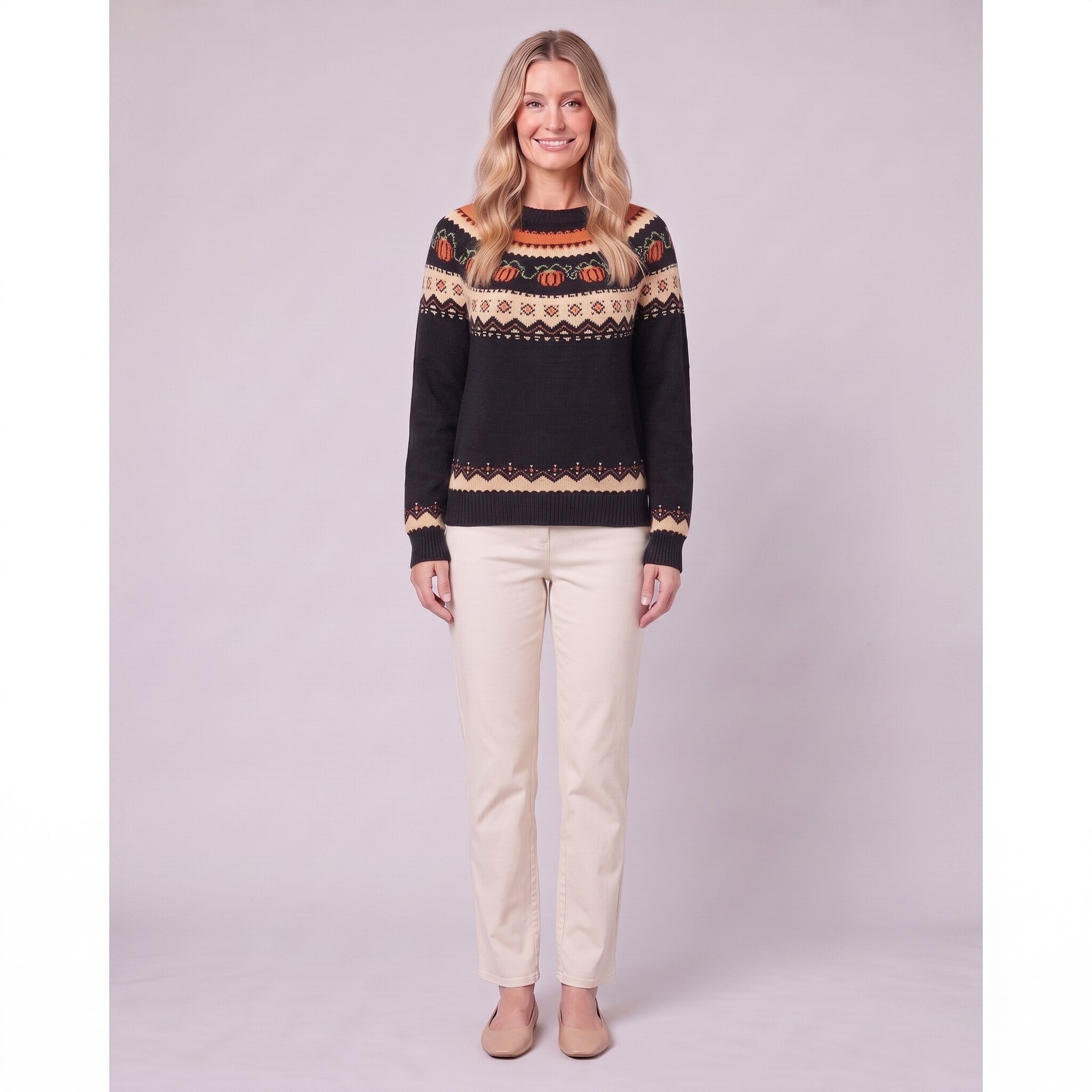 Nieve pumpkin fair isle sweater in black, front view on model with cream trousers