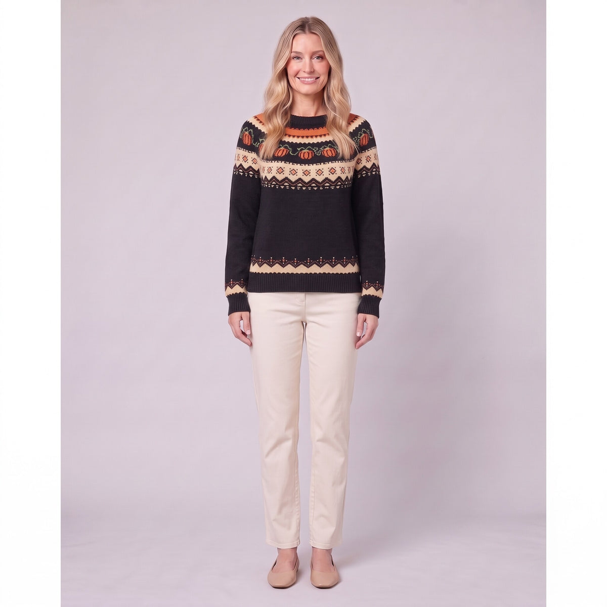 Nieve pumpkin fair isle sweater in black, front view on model with cream trousers