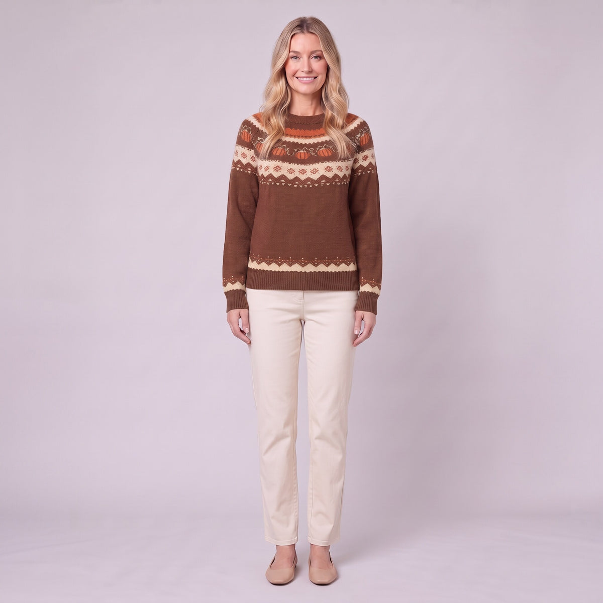 Nieve pumpkin fair isle sweater in chocolate brown, front view on model with cream trousers