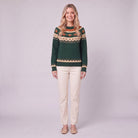 Nieve pumpkin fair isle sweater in forest green, front view on model with cream trousers