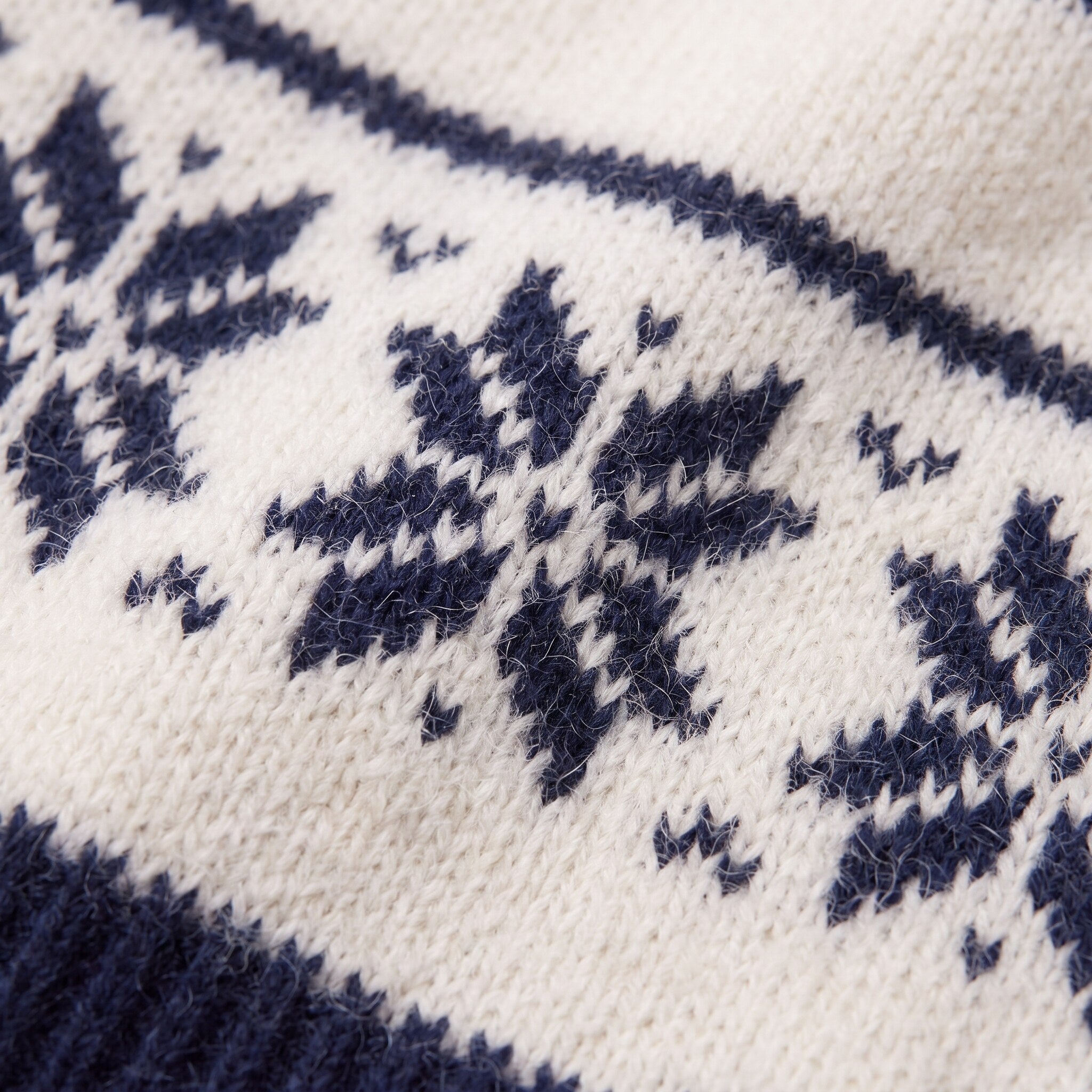 Nova snowflake knit sweater fabric detail, Nordic snowflake jacquard close-up in navy on cream