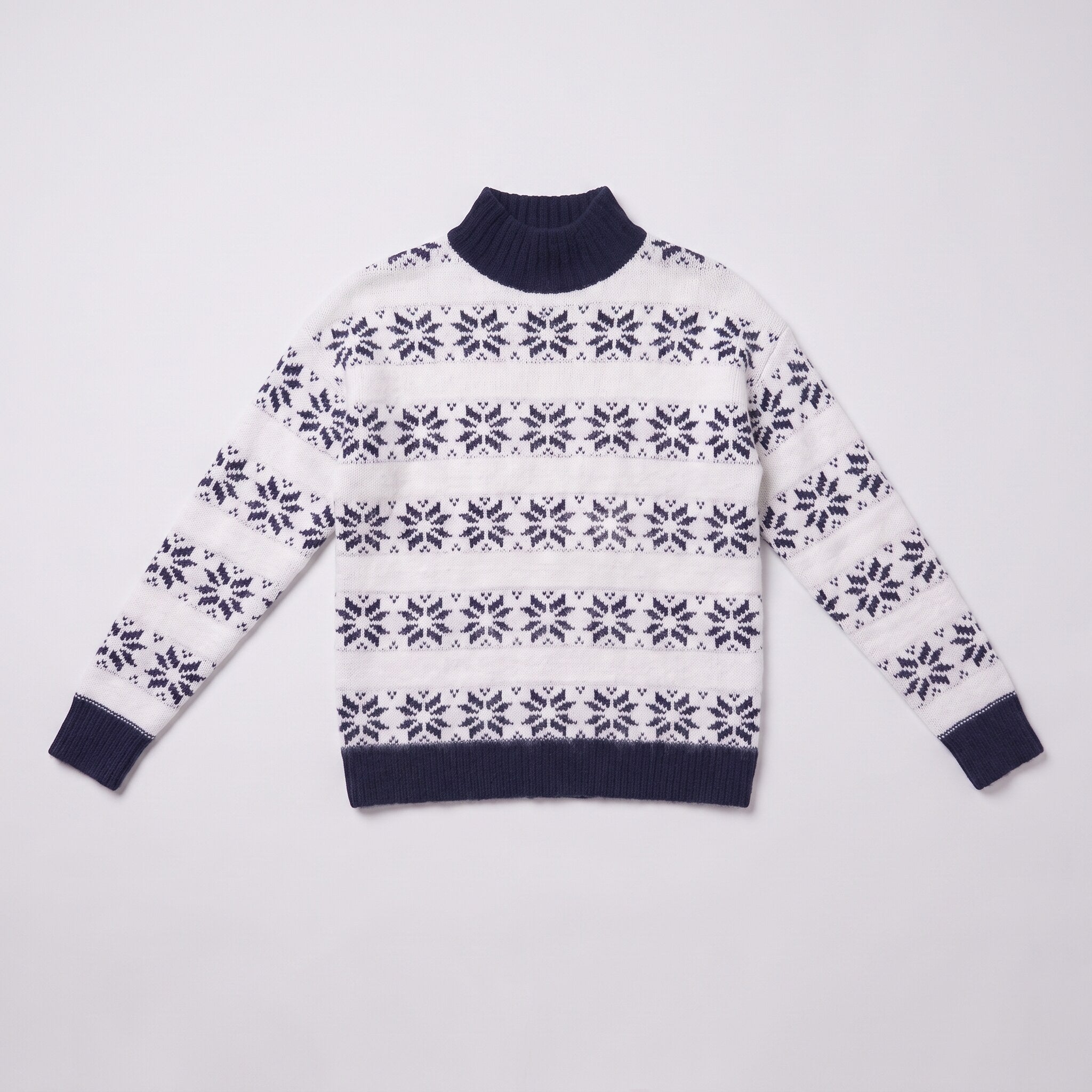 Nova snowflake knit sweater flat lay, full garment in navy blue Nordic pattern on light grey