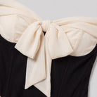 Close-up of the cream bow and corset seams on the Odette mini dress