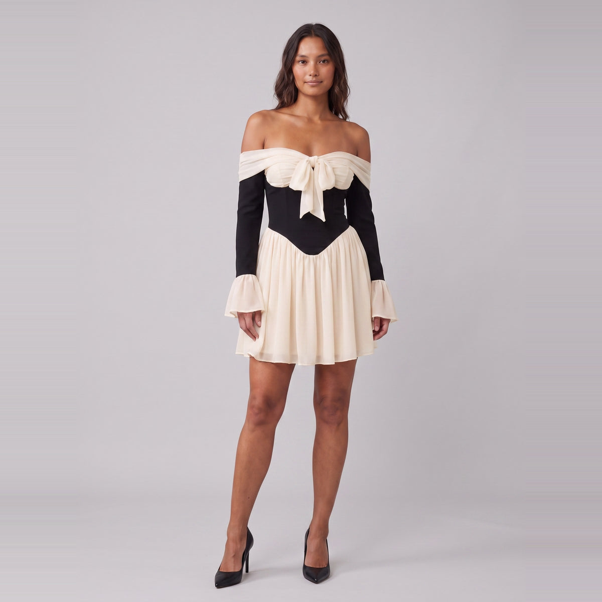 Odette off-shoulder corset mini dress in black with a cream bow at the bust, front view