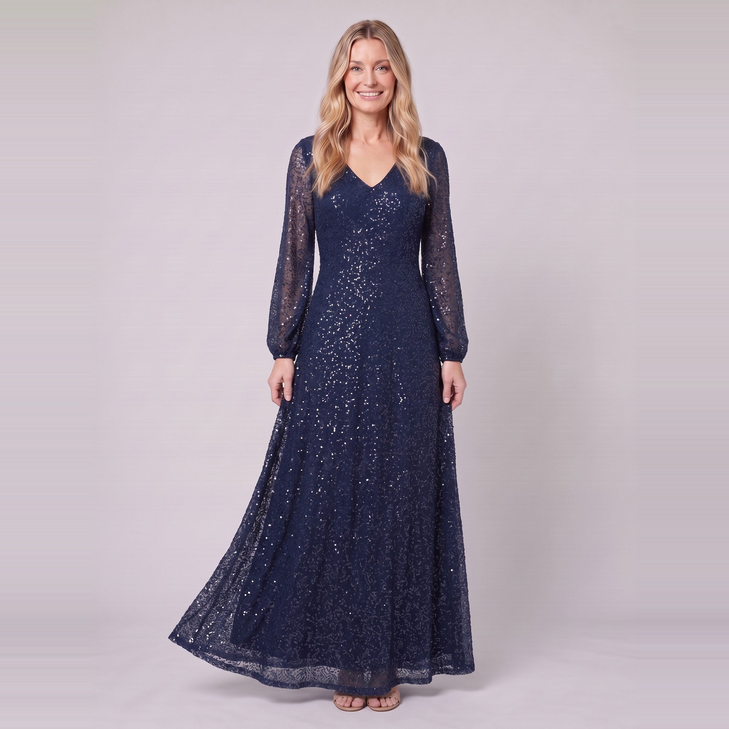Rayven navy sequin gown holding the skirt, standing view