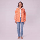 Saoirse distressed denim shacket in coral orange, front view on model