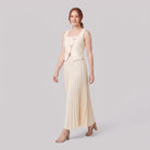 Apricot co-ord set, walking pose showing the pleated maxi skirt