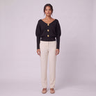 Solenne boat neck sweater with gold buttons in black, front view on model