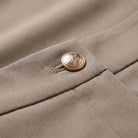 Valdis pleated wide leg trousers detail, gold button and smooth suiting fabric close-up