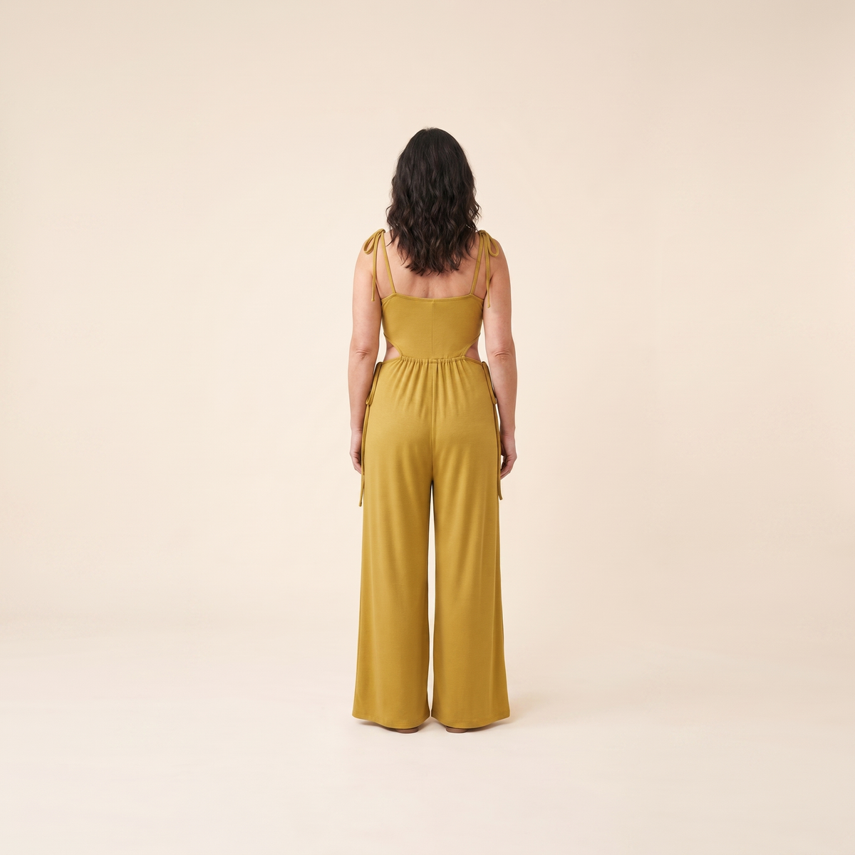 Mustard jumpsuit with a cut-out waist, back view